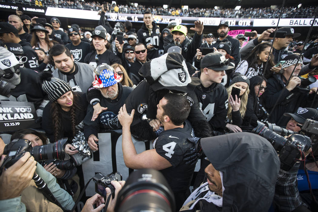 Oakland Raiders quarterback Derek Carr (4) hugs fans in the "Black Hole" after Oaklan ...