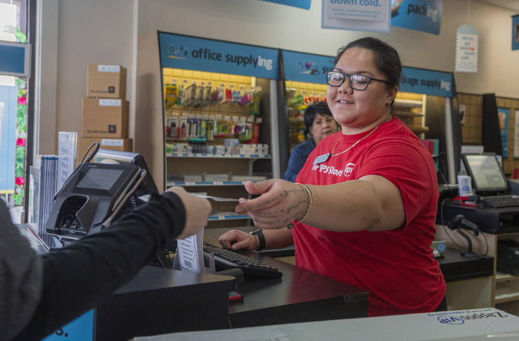 Sales associate Alyssa Prescott-Lene helps a costumer at The UPS Store located in the Green Val ...