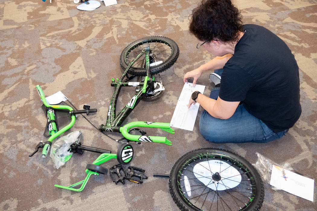 GLVAR member Diana Jenkins assembles a bike to be donated to the annual KLUC toy drive. (GLVAR)