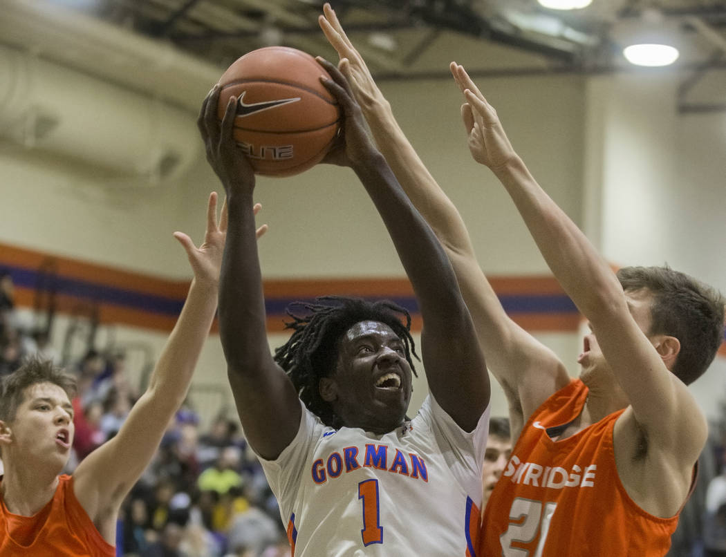 Bishop Gorman junior guard Will McClendon (1) drives baseline over Skyridge senior forward Luke ...