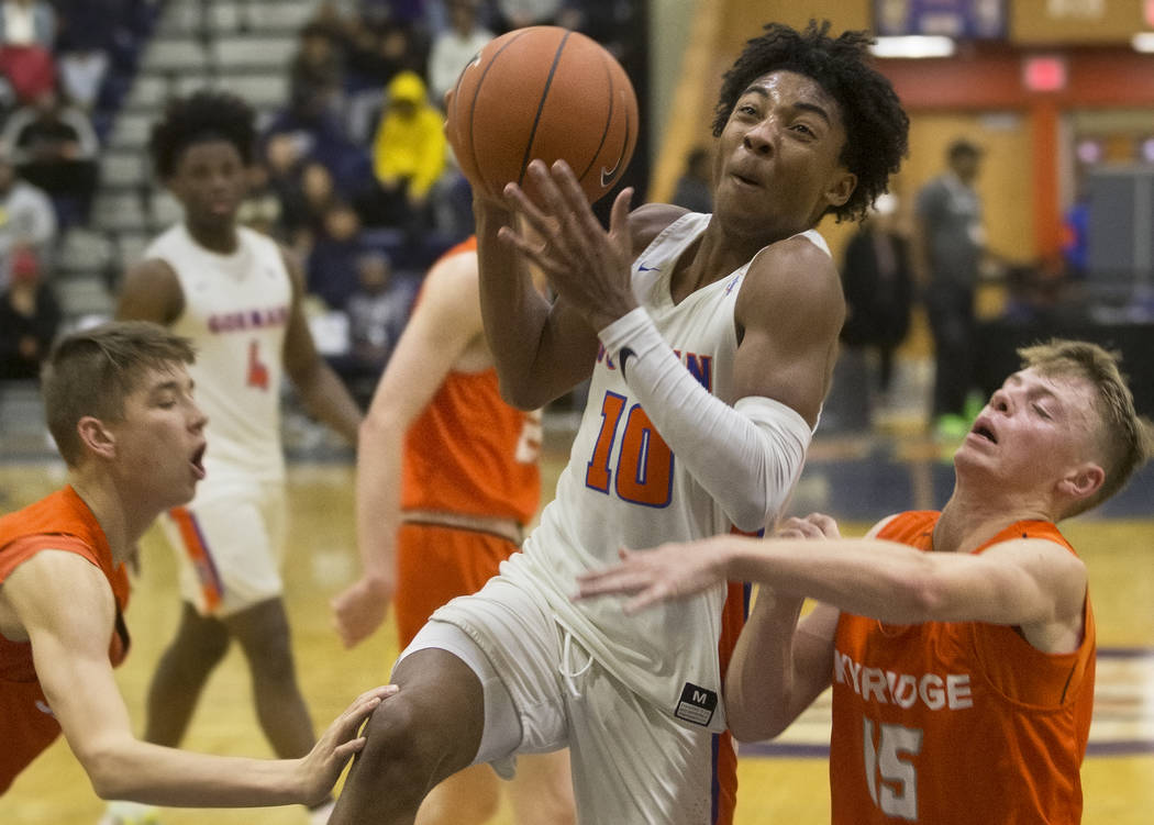 Bishop Gorman junior guard Zaon Collins (10) drives past Skyridge sophomore point guard Nick Ho ...