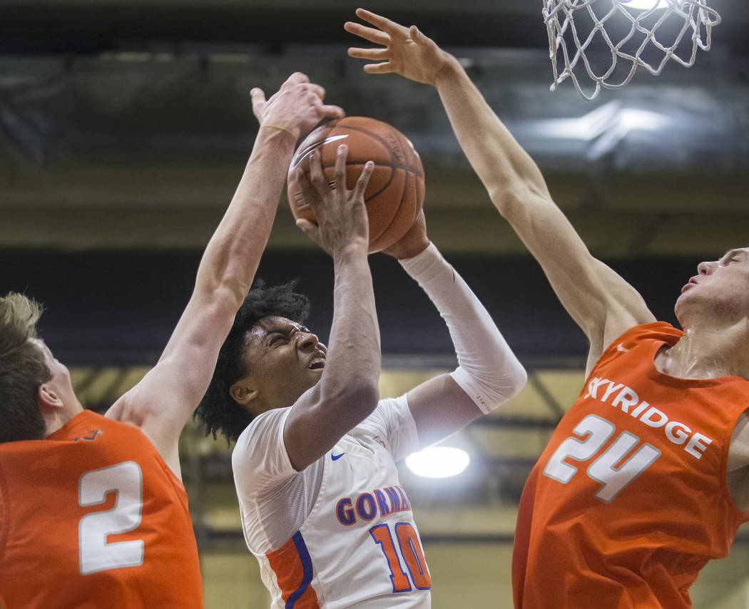 Bishop Gorman junior guard Zaon Collins (10) splits Skyridge defenders Trevon Snoddy (24) and B ...