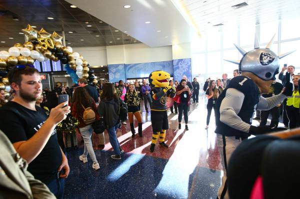 Golden Knights mascot Chance and Raiders mascot Raider Rusher welcome passengers deplaning from ...