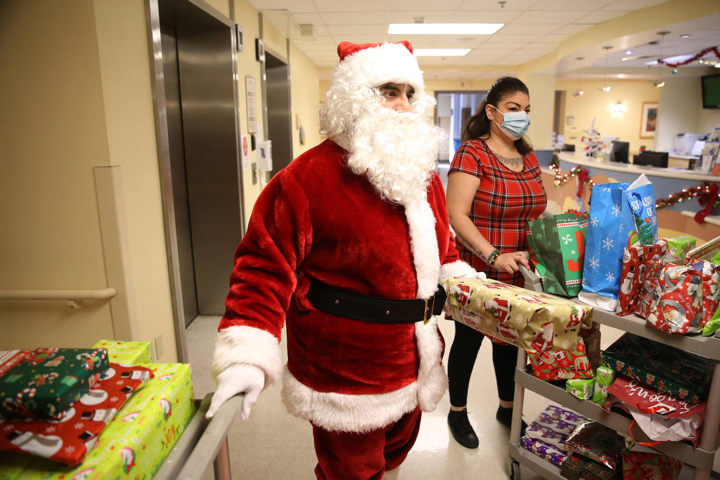 Serafin Calvo-Arreola, left, City of North Las Vegas parking services manager, dressed as Santa ...