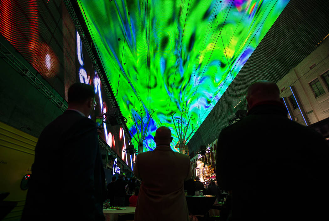 People watch the recently-upgraded Viva Vision screen during a preview of the new light show, & ...