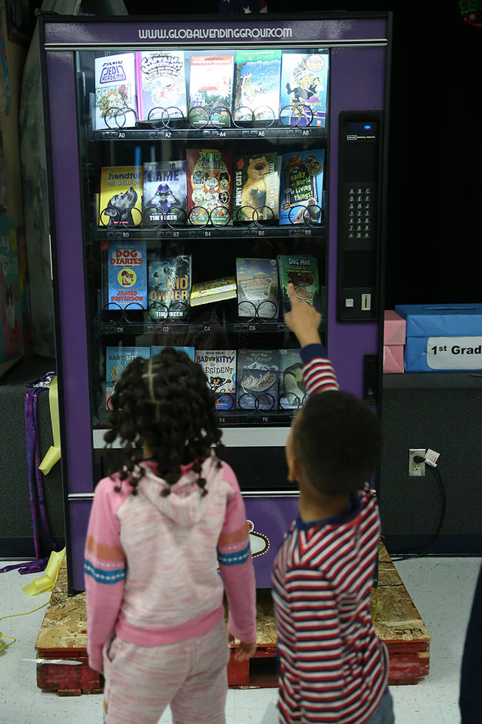 Students look at a book vending machine at Frank Kim Elementary School in Las Vegas, Thursday, ...