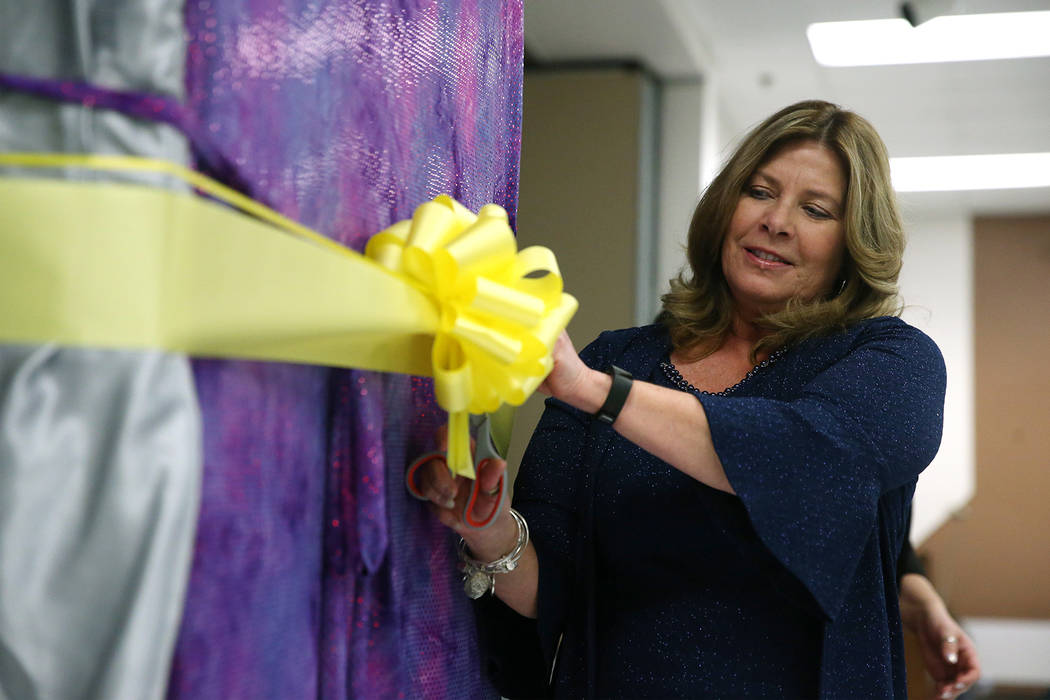 Principal Cathleen Furtado cuts a ribbon during an unveiling ceremony for a book bending machin ...