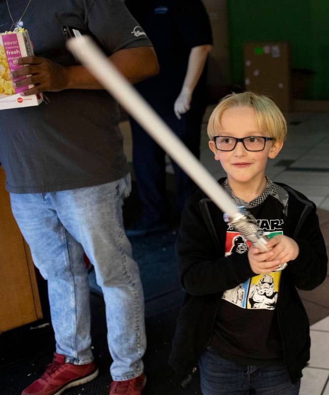 John Athan, 6, waves his light saber at the Star Wars: The Rise of Skywalker premiere at AMC To ...