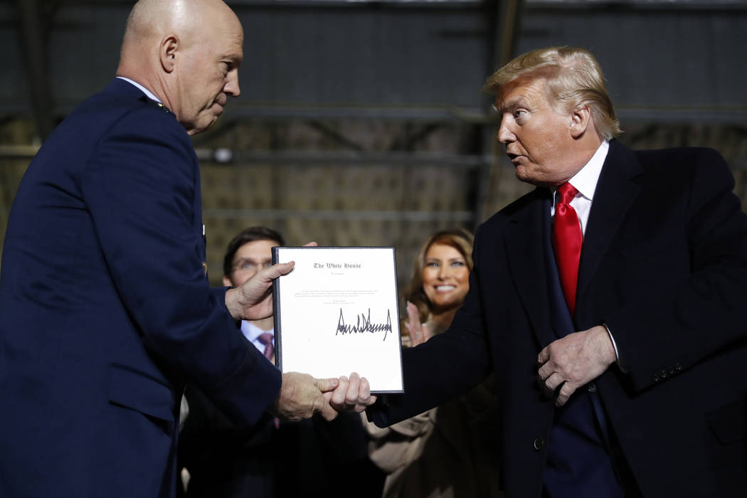 President Donald Trump shakes hands with Gen. Jay Raymond, after signing the letter of his appo ...