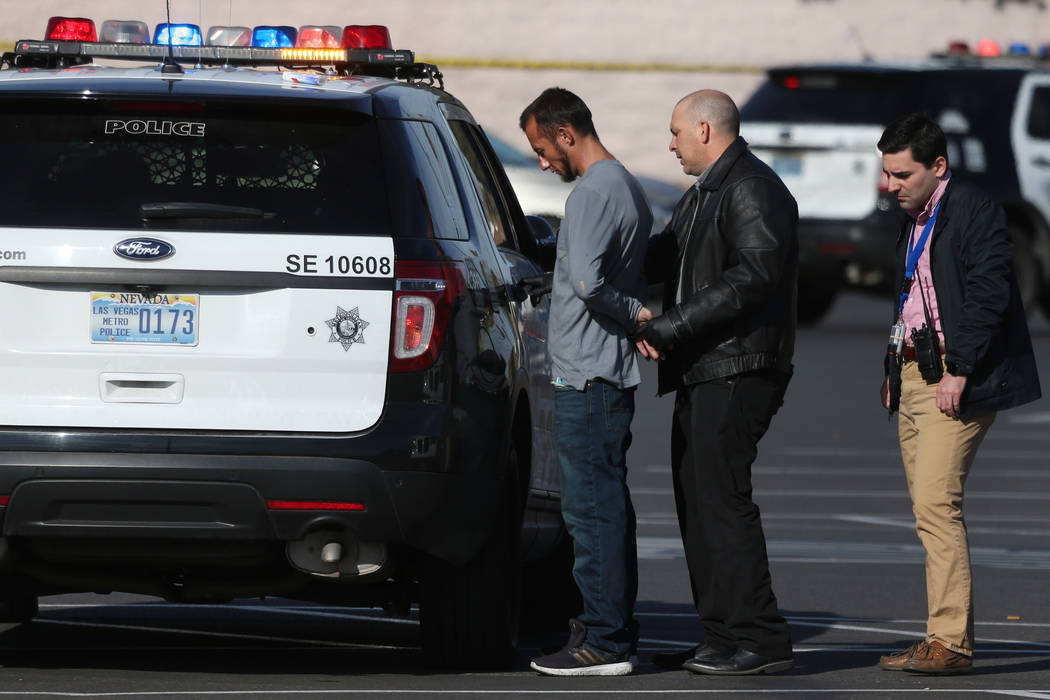 A person is detained at the scene of a shooting at the Tropicana Centre, 3000 block of E Tropic ...