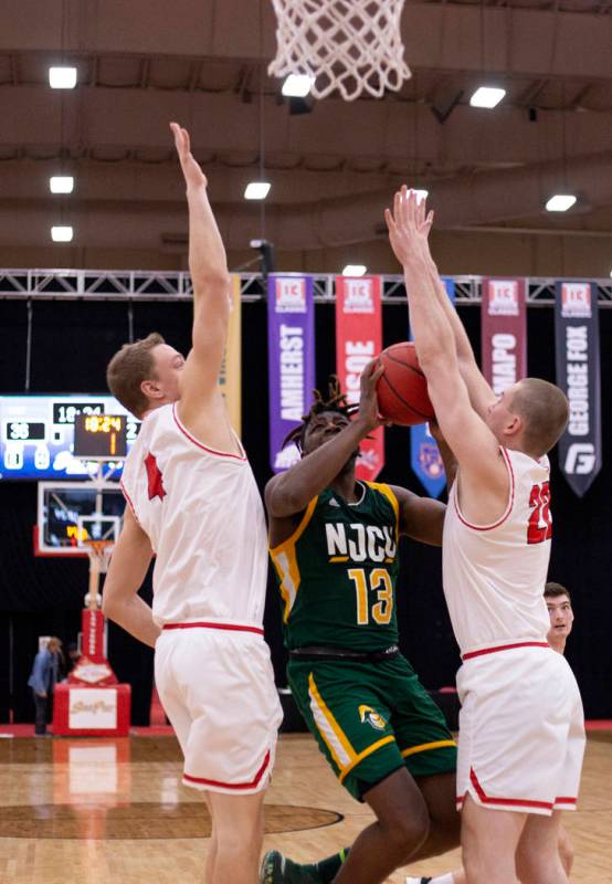 New Jersey City University's small forward Jaimik Moore (13) attempts to shoot past University ...