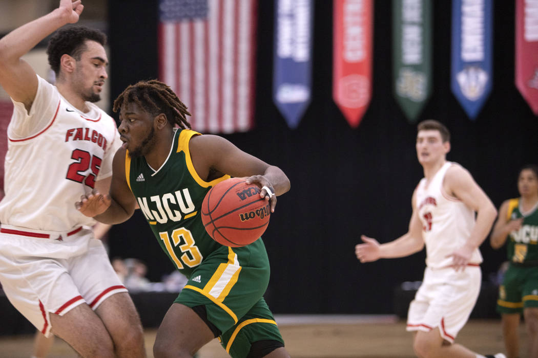 New Jersey City University's small forward Jaimik Moore (13) pushes past University of Wisconsi ...