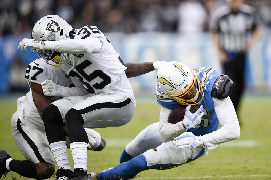 Oakland Raiders free safety Curtis Riley, middle, collides with teammate cornerback Trayvon Mul ...