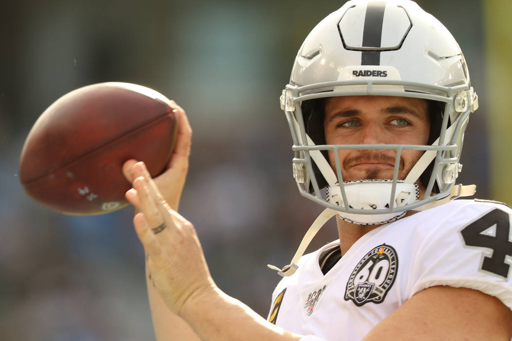 Oakland Raiders quarterback Derek Carr (4) warms up on the sideline during the first half of an ...