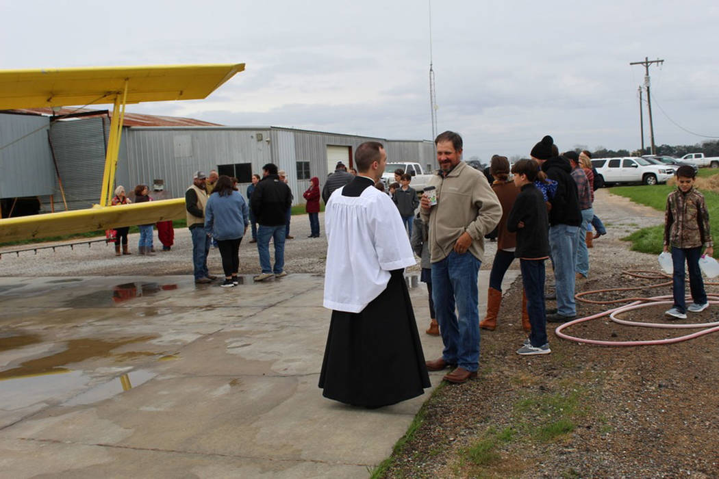 Members of St. Anne Church in Cow Island, Louisiana, called upon crop duster pilots to help spr ...