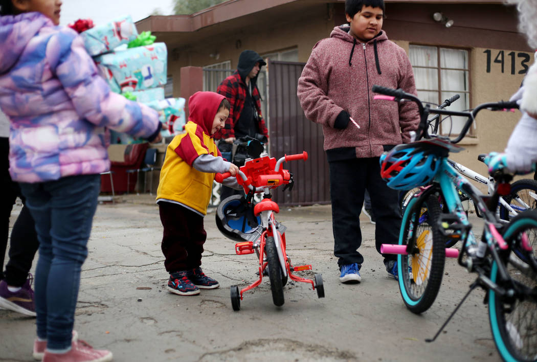 Ruben Figueroa, 3, center, looks at his new bike delivered to him by the City of North Las Vega ...