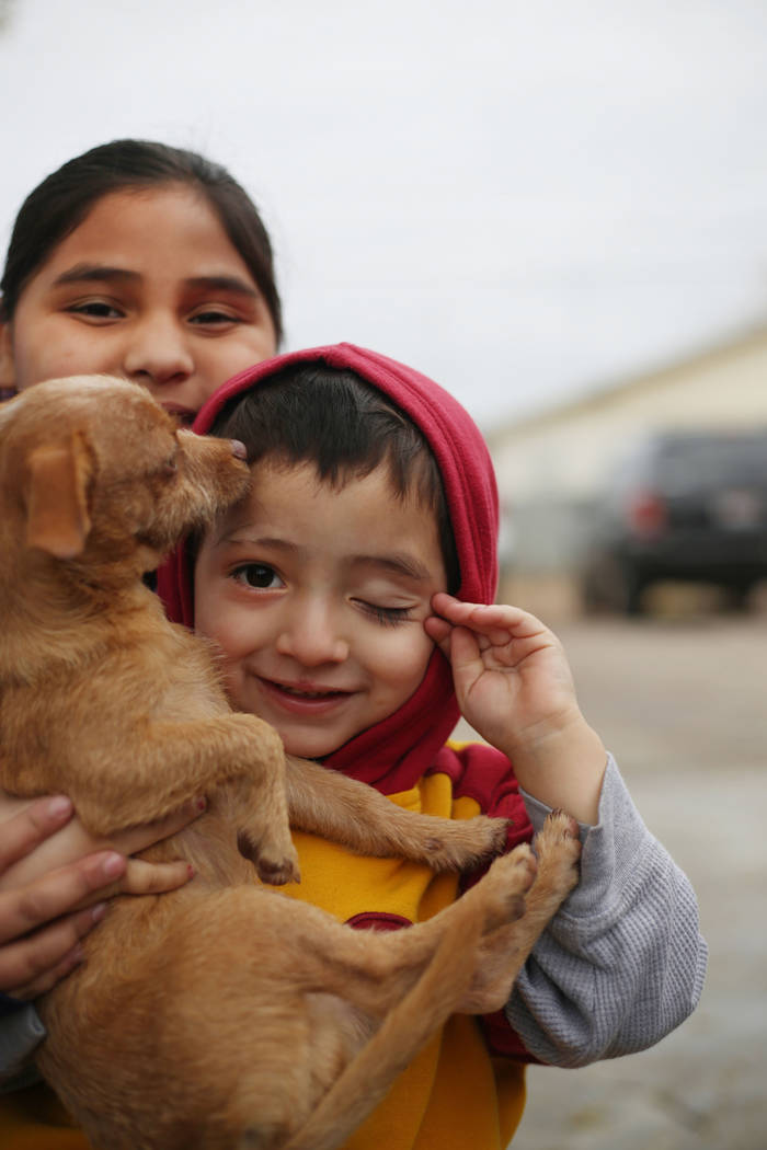 Juanita Morales, 9, left, and Ruben Figueroa, 3, hold their dog Peanut Butter with excitement a ...