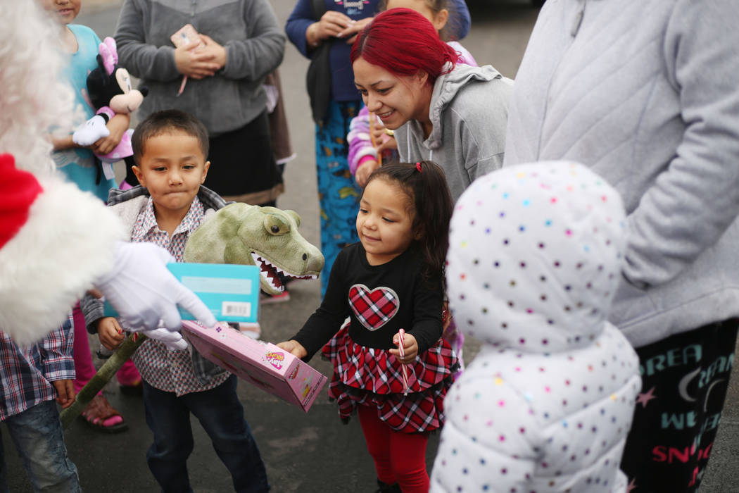 Kids are gifted toys from Santa proved by the City of North Las Vegas Fire Department in a neig ...