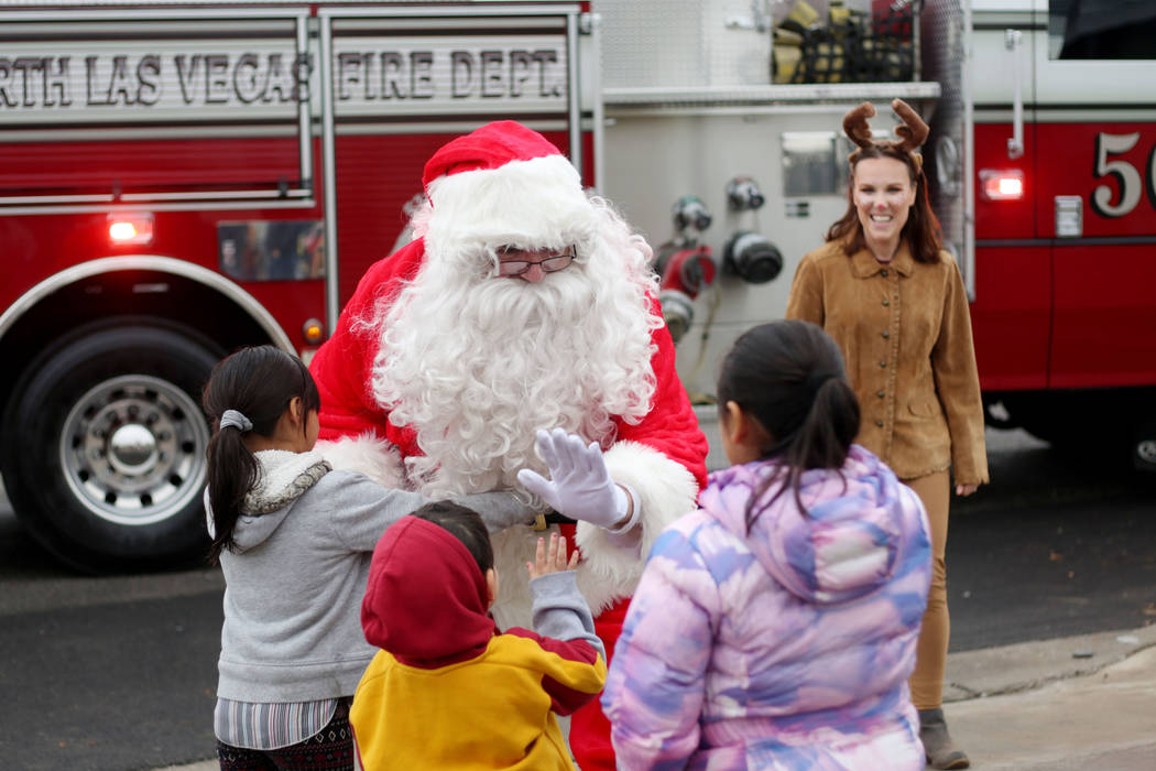 The Lopez and Morales family say thank you to Santa after the City of North Las Vegas Fire Depa ...