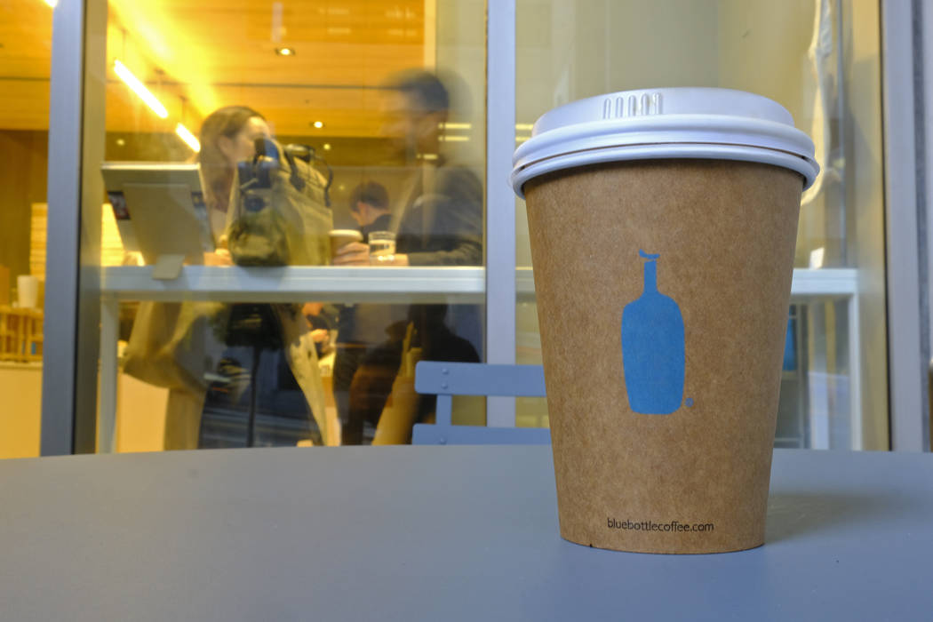 In this Thursday, Dec. 12, 2019 photo, a Blue Bottle Coffee paper to-go cup rests on a table ou ...