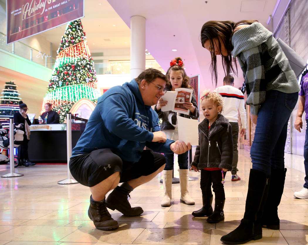 The Kephart family, Timothy, Rylynn, 8, Hayden, 2, and Nikci check out their Santa photos while ...