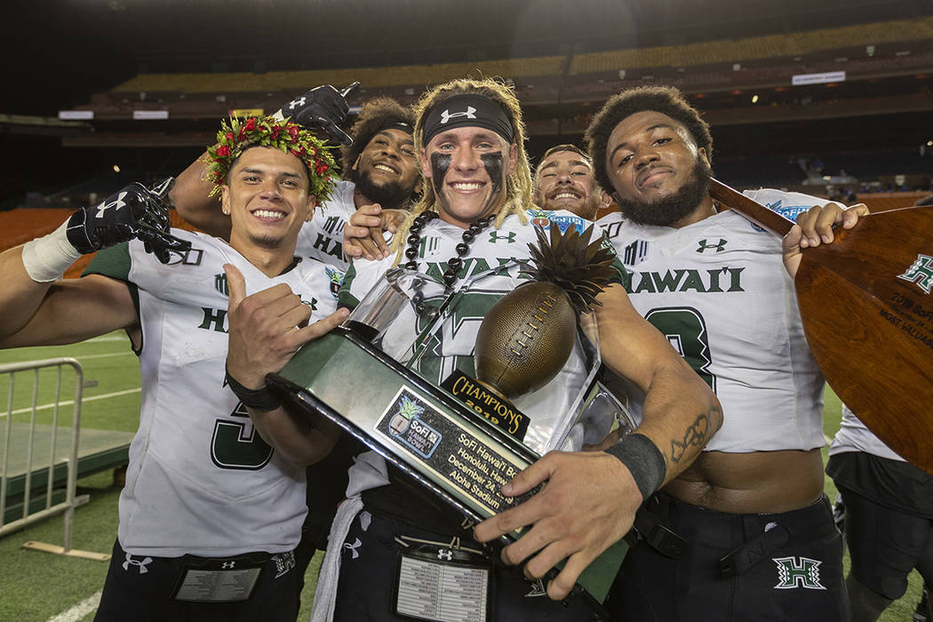 Hawaii wide receiver Jason-Matthew Sharsh, left, quarterback Cole McDonald, center, and defensi ...