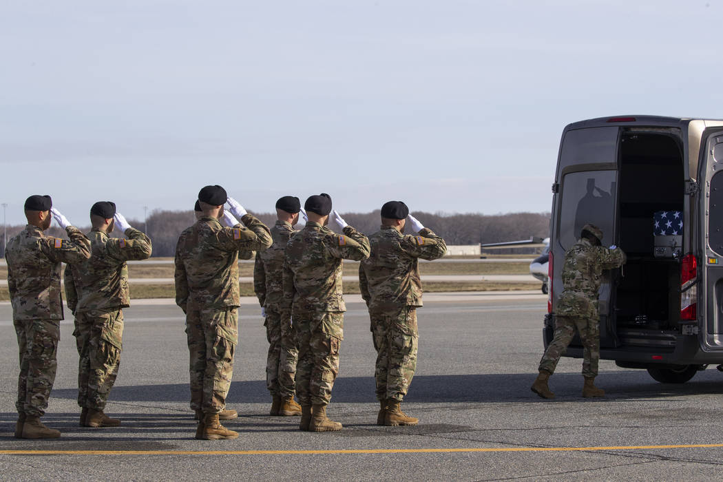 An Army carry team slaues a transfer case containing the remains of U.S. Army Sgt. 1st Class Mi ...