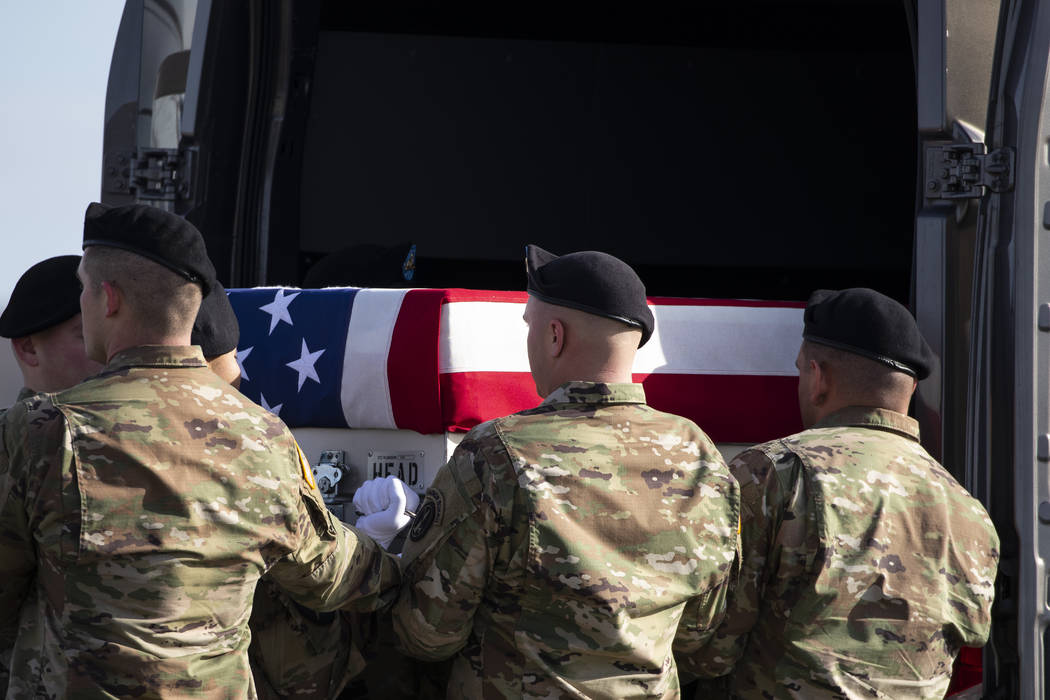 An Army carry team loads a transfer case containing the remains of U.S. Army Sgt. 1st Class Mic ...