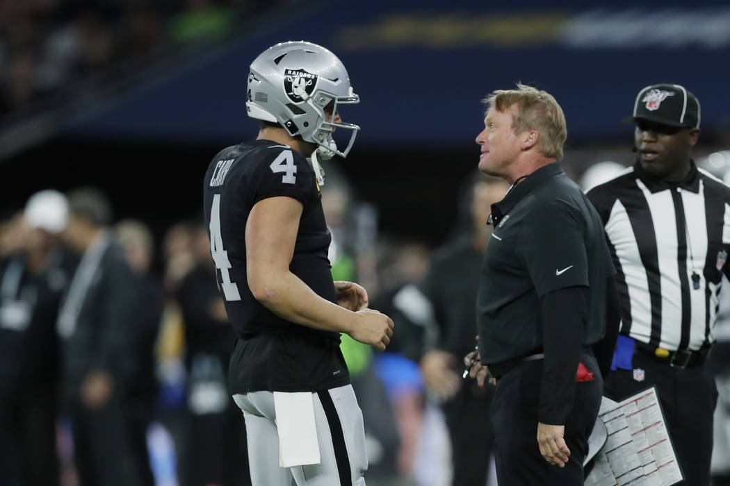 Oakland Raiders head coach Jon Gruden, front right, talks with quarterback Derek Carr (4) durin ...