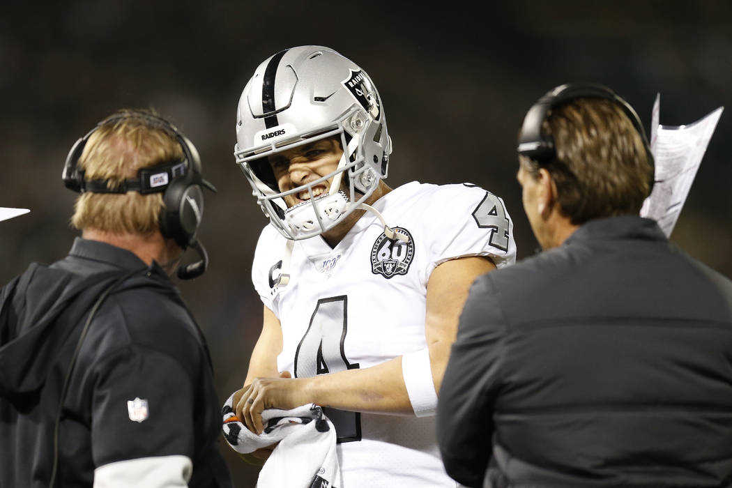 Oakland Raiders quarterback Derek Carr (4) talks with head coach Jon Gruden, left, and offensiv ...