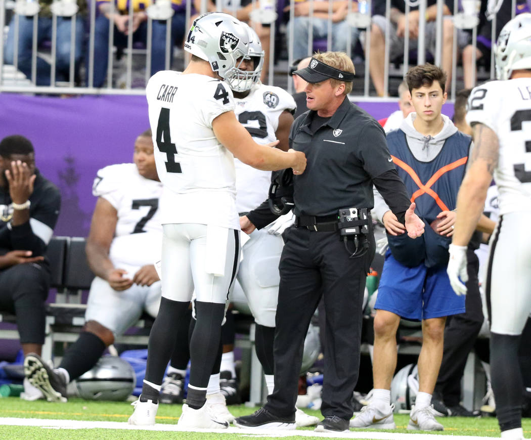 Oakland Raiders head coach Jon Gruden, right, gestures to quarterback Derek Carr (4) during a c ...