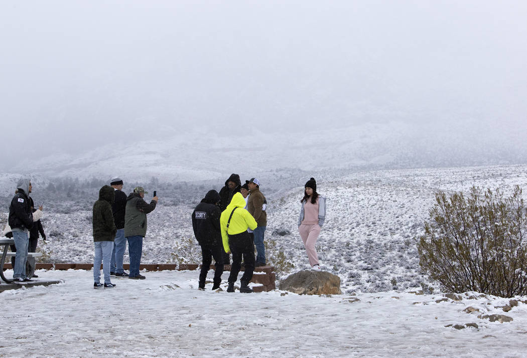 People pose for photos in the snow at Red Rock Canyon Overlook on Thursday, Dec. 26, 2019, in L ...