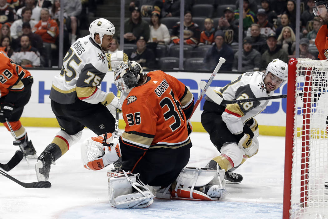 Anaheim Ducks goaltender John Gibson, center, stops a shot between Vegas Golden Knights' Ryan R ...