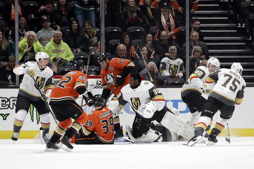 Vegas Golden Knights goaltender Malcolm Subban, center right, loses his helmet as he stops a sh ...