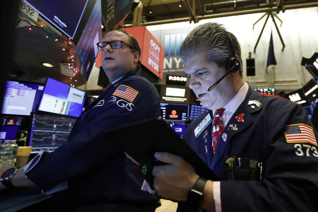 In this Dec. 13, 2019, file photo specialist Gregg Maloney, left, and trader John Panin work on ...