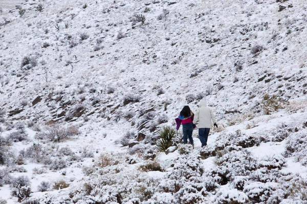 People walk through the snow at Red Rock Canyon Overlook on Thursday, Dec. 26, 2019, in Las Veg ...