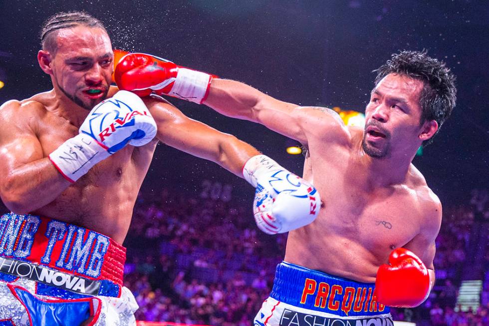 Keith Thurman is punched in the face by Manny Pacquiao during Round 5 of their WBA super welter ...