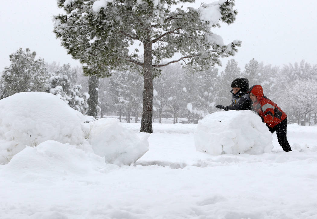 Cameron Partovi, right, and Sammy Kamyar build a snowman in South Tower Park in Summerlin as sn ...