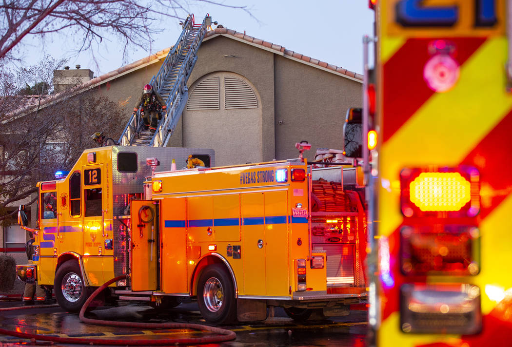 Firefighters with the Clark County Fire Department descend the roof of an apartment at the Glor ...