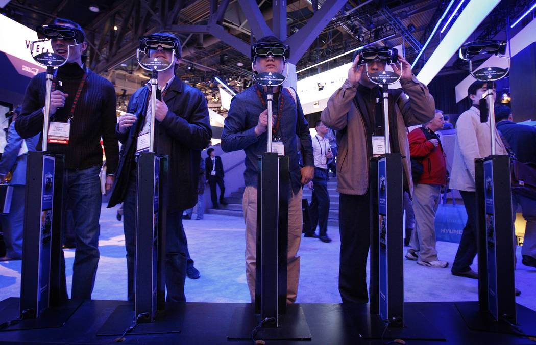 Showgoers try out 3D glasses at the Panasonic booth during the 2010 Consumer Electronics Show. ...