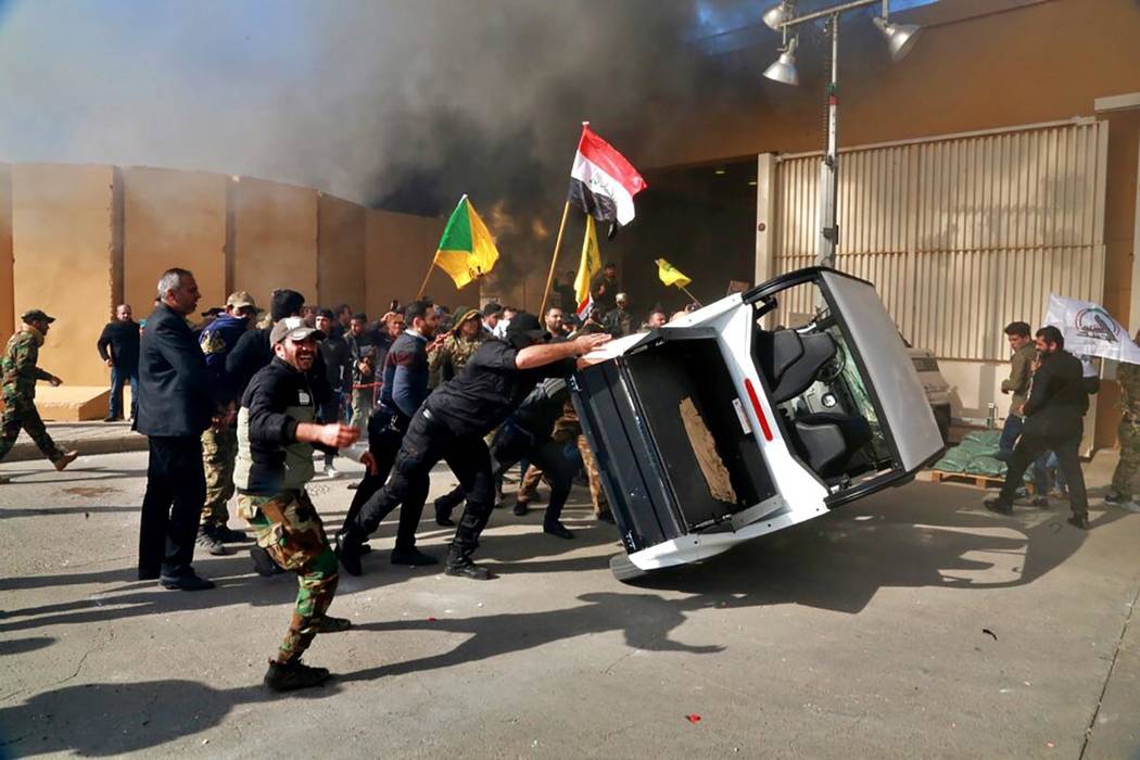 Protesters damage property inside the U.S. embassy compound, in Baghdad, Iraq, Tuesday, Dec 31, ...