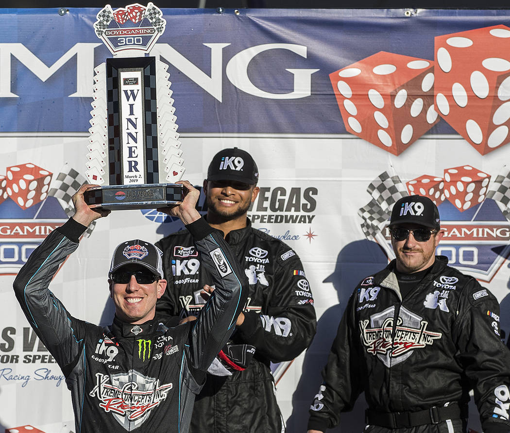 Kyle Busch, left, hoists the trophy for winning the NASCAR Xfinity Series Boyd Gaming 300 on Sa ...