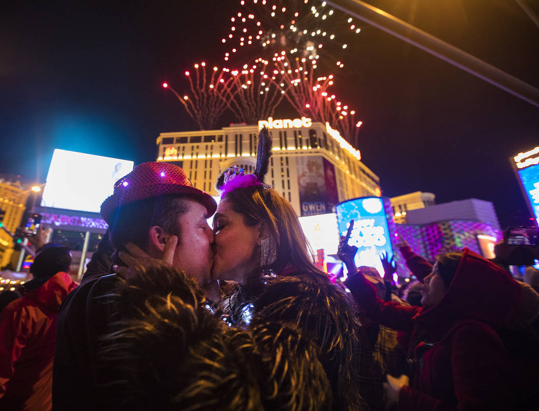 Moses Carpio, of Las Vegas, kisses his girlfriend Teresa Enriquez, of Juarez, on New Year&#x201 ...