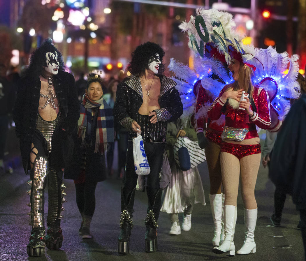 Show girls, right, share a moment with street performers dressed in Kiss attire on the Strip on ...