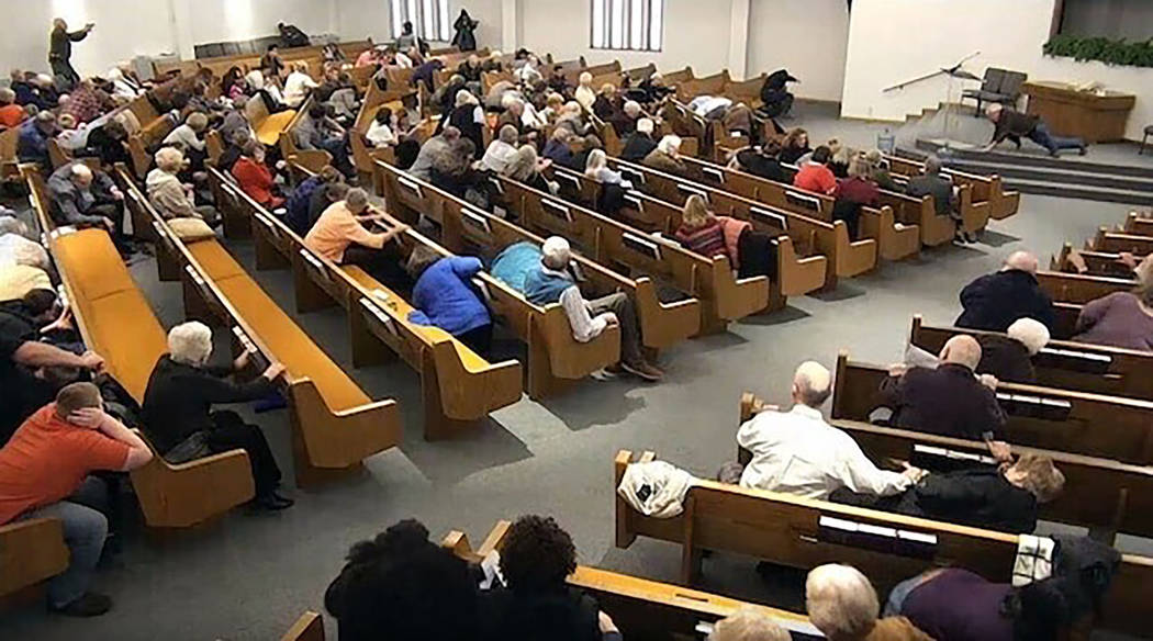 Churchgoers take cover while a congregant armed with a handgun, top left, engages a man who ope ...