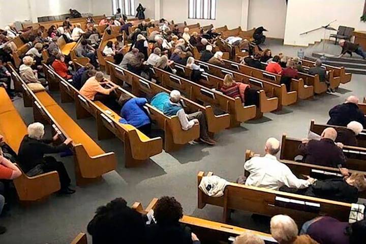 Churchgoers take cover while a congregant armed with a handgun, top left, engages a man who ope ...