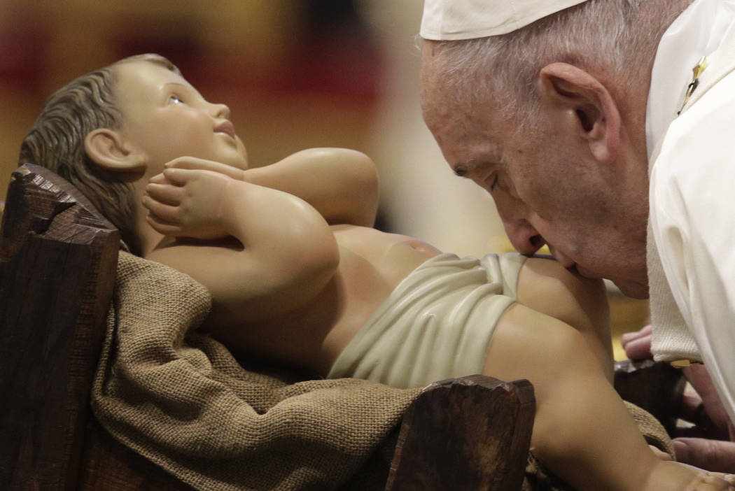 Pope Francis kisses a statue of Baby Jesus as he presides over a Mass for the solemnity of St. ...