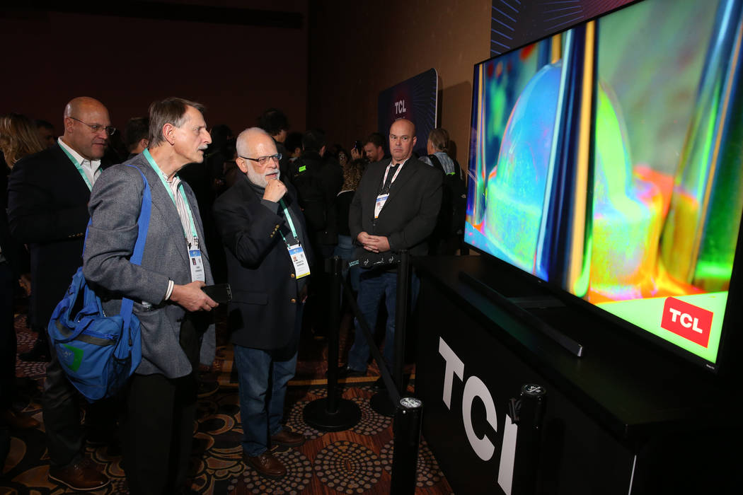 Members of the news media check out the TCL 8K Mini-LED TV during the TCL news conference at Ma ...