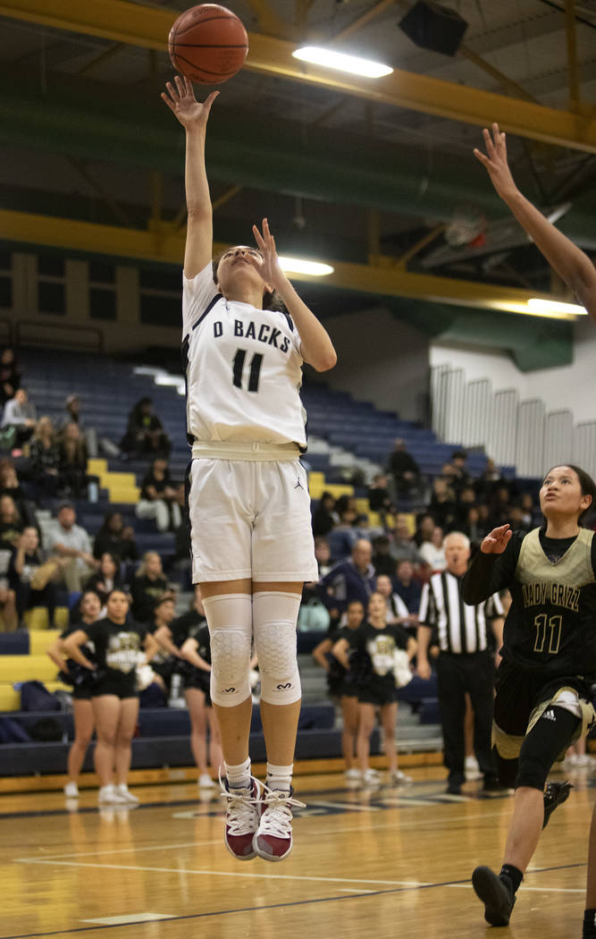 Desert Oasis's forward Olivia Bigger (11) shoots a point during the game against Spring Valley ...