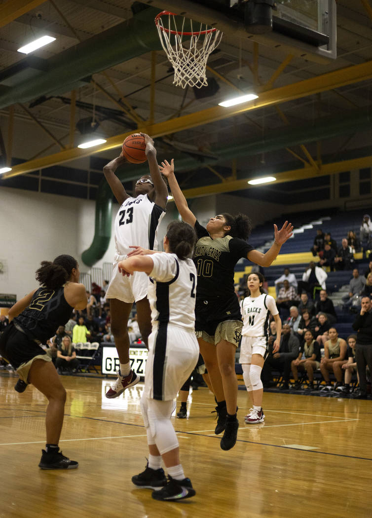 Desert Oasis's forward Desi-Rae Young (23) blocks a Spring Valley point as Spring Valley's guar ...